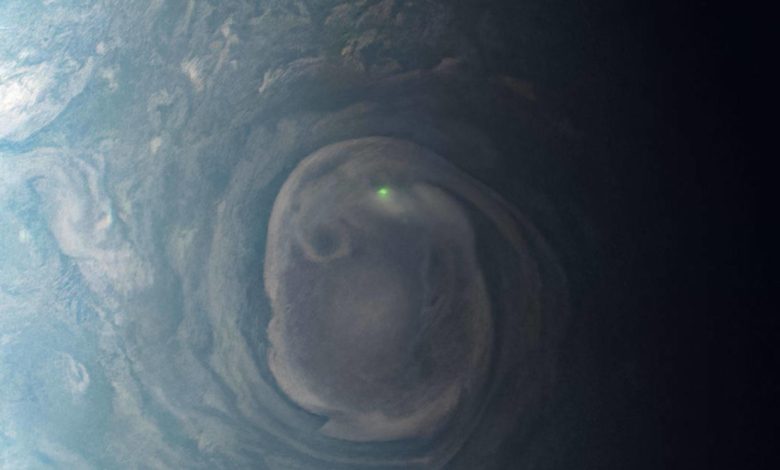 An image from Jupiter taken by NASA's JunoCam shows a bright green dot on the planet's north pole. The glowing orb is a lighting bolt, NASA says.NASA